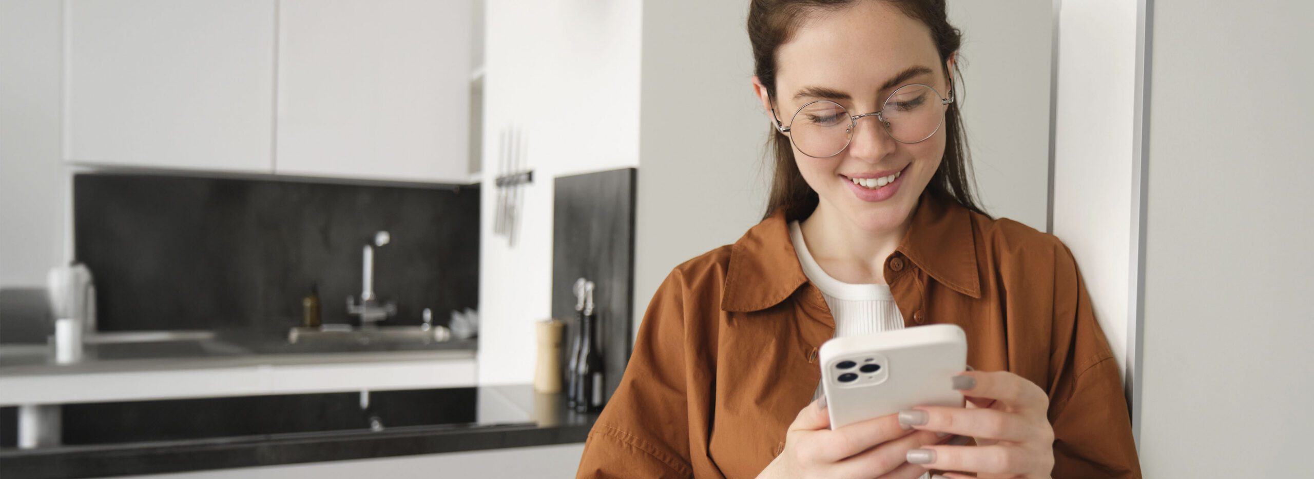 beautiful-woman-checking-social-media-while-using-smartphone-home-smiling-young-female-using